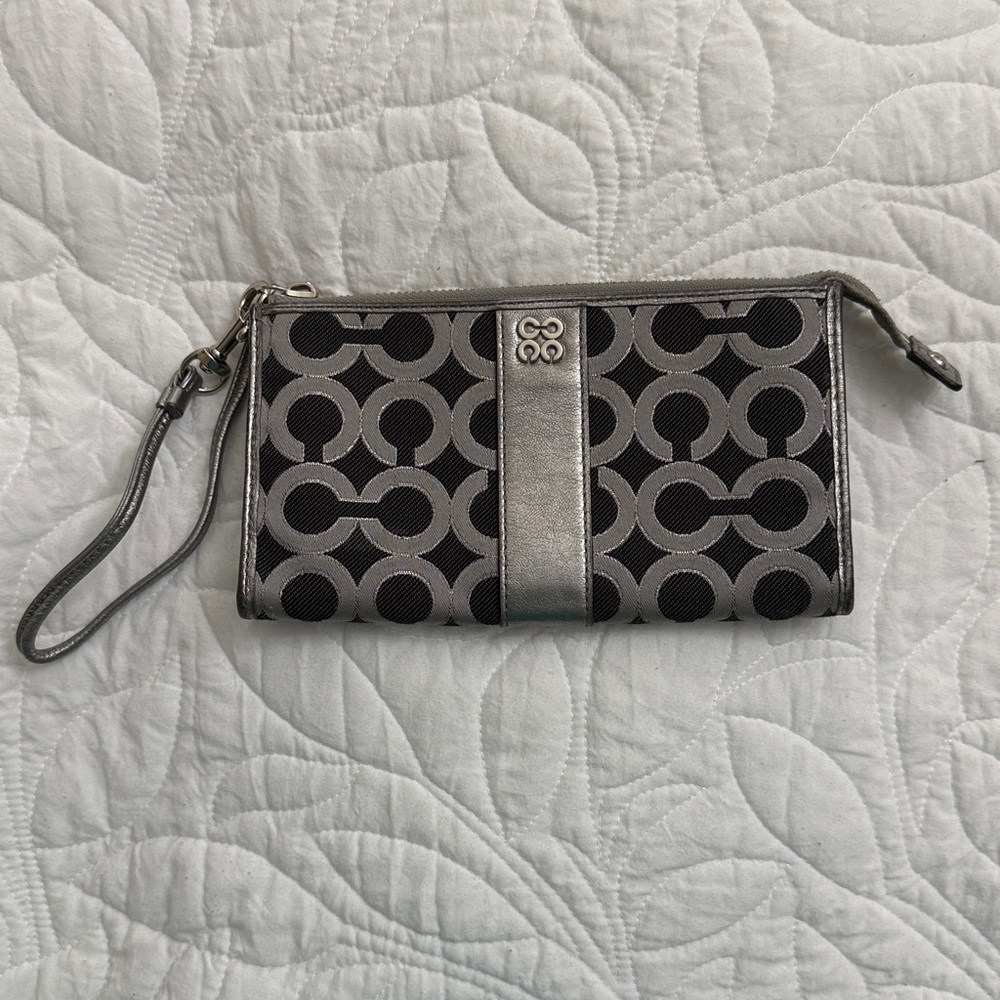 Elegant Coach Julia Op Art Black and Silver Wristlet with pink interior.